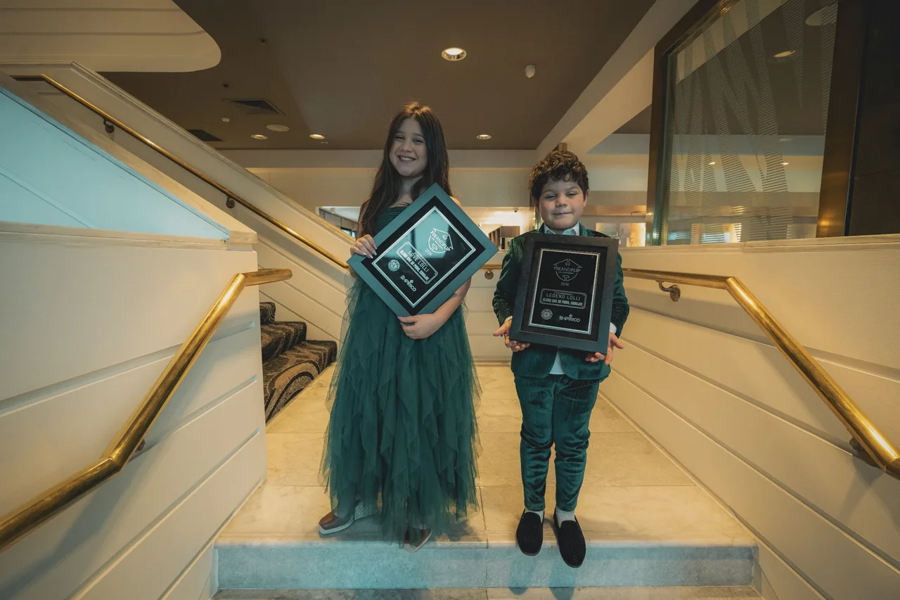The Lolli kids holding their plaques on the stairs