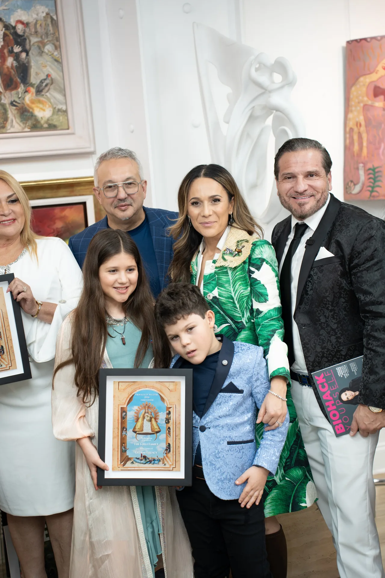 The Lolli family with a framed artwork at the gallery